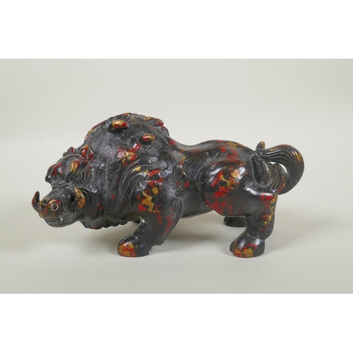 181 - An oriental filled bronze figure of a boar with remnants of gilt and red lacquer patina, 20cm long