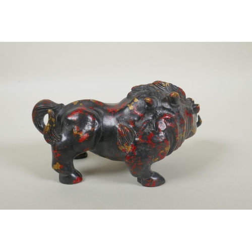 181 - An oriental filled bronze figure of a boar with remnants of gilt and red lacquer patina, 20cm long