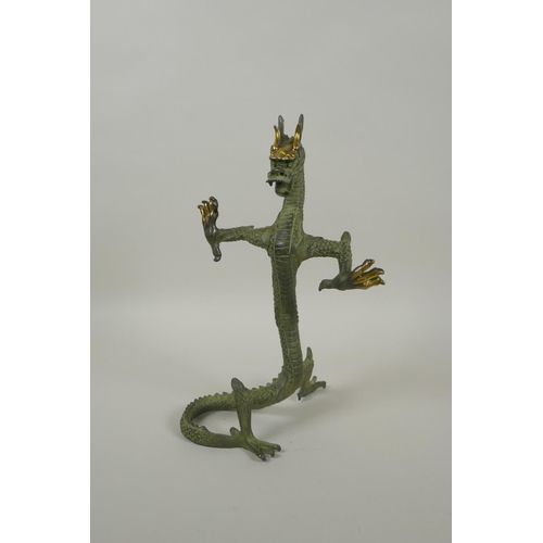 183 - A Chinese bronze figure of a dragon with gilt highlights, 24cm high