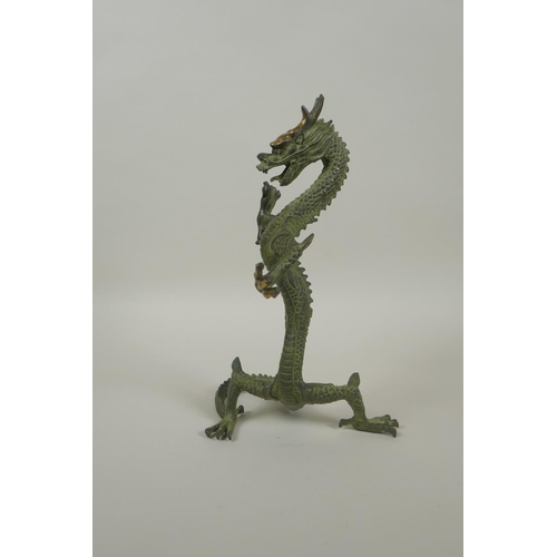 183 - A Chinese bronze figure of a dragon with gilt highlights, 24cm high