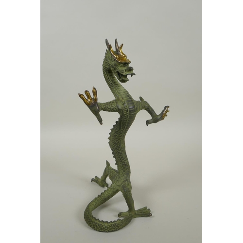 183 - A Chinese bronze figure of a dragon with gilt highlights, 24cm high