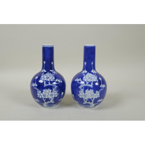 191 - A pair of late C19th/early C20th Chinese blue and white porcelain bottle vases decorated with prunus... 