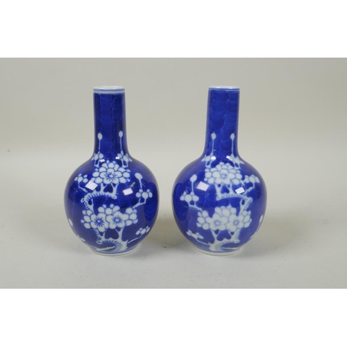 191 - A pair of late C19th/early C20th Chinese blue and white porcelain bottle vases decorated with prunus... 