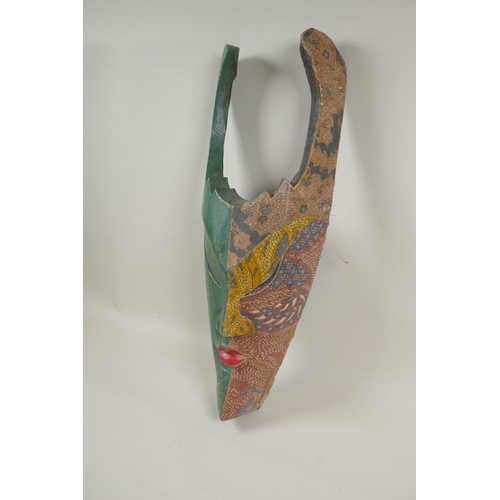 193 - A Balinese carved wood wall mask with painted and batik textile decoration, 50cm