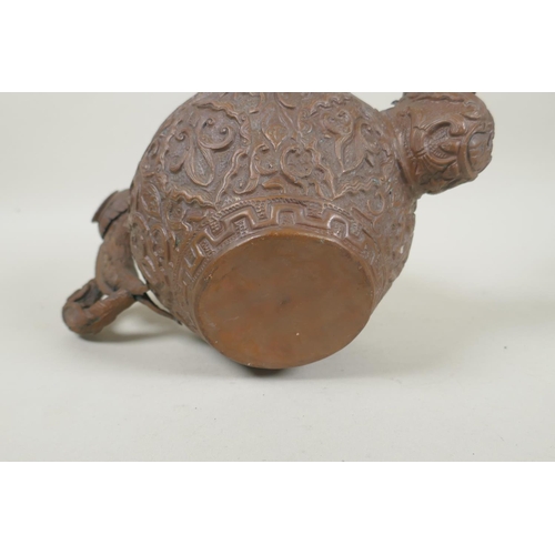 197 - A Tibetan coppered metal kettle with a dragon handle and spout, and repousse vine decoration, 17cm h... 