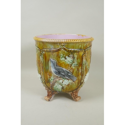 198 - An antique Majolica jardiniere decorated with birds and flowers, raised on four scrolling feet, 23cm... 