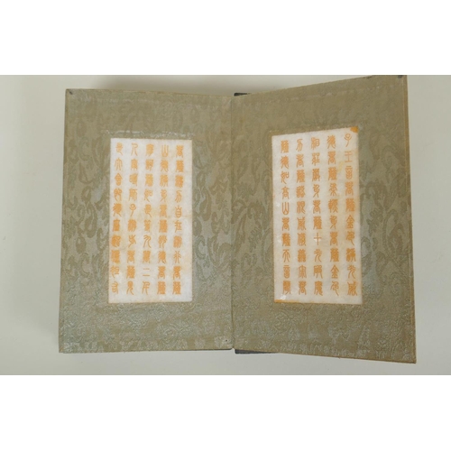 205 - A Chinese wood and silk bound book with white jade tablet pages bearing chased and gilt inscriptions... 