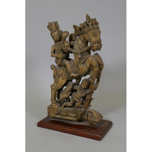 21 - An Indian carved wood figure of a warrior on prancing horse, 48cm high