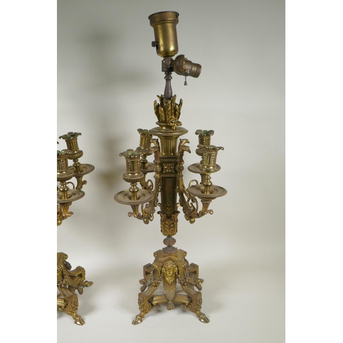 217 - A pair of gilt bronze four branch candelabra, decorated with swags, masks and arrow fletchings, the ... 