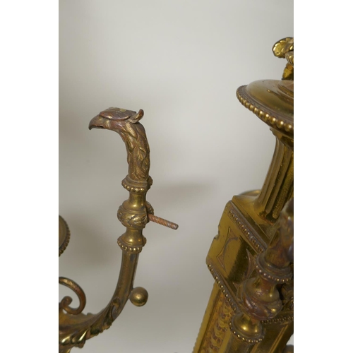 217 - A pair of gilt bronze four branch candelabra, decorated with swags, masks and arrow fletchings, the ... 