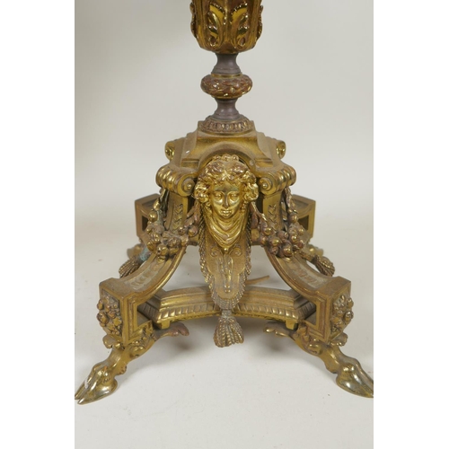 217 - A pair of gilt bronze four branch candelabra, decorated with swags, masks and arrow fletchings, the ... 