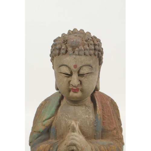 220 - A Chinese carved, painted and distressed wood Buddha, 22cm high