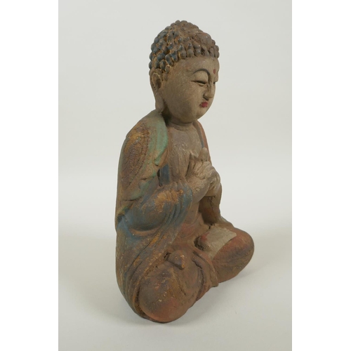 220 - A Chinese carved, painted and distressed wood Buddha, 22cm high