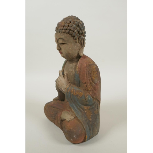 220 - A Chinese carved, painted and distressed wood Buddha, 22cm high