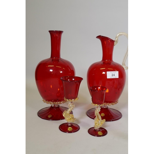 24 - Mazzega Murano, ruby glass ewer with gilt inclusions, 29cm high, a carafe and two drinking glasses