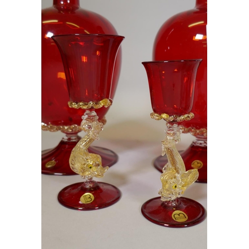 24 - Mazzega Murano, ruby glass ewer with gilt inclusions, 29cm high, a carafe and two drinking glasses