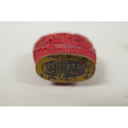 251 - A Chinese cinnabar lacquer style snuff bottle with riverside landscape decoration, Qianlong mark to ... 