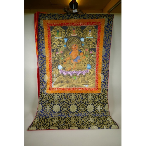 255 - A Tibetan painted thangka depicting Jambhala, in a silk mount, 82 x 126cm