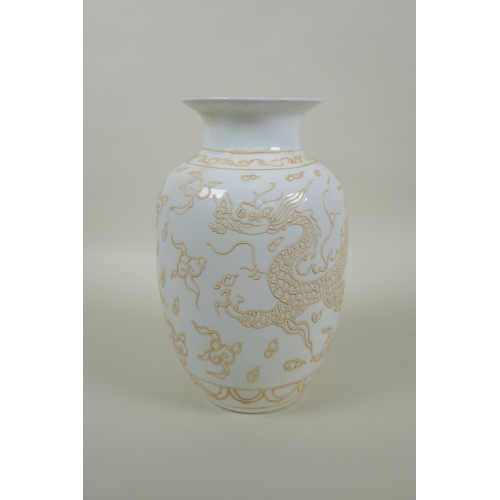 258 - A Chinese white ground porcelain vase with raised dragon decoration, character marks to base, 22cm h... 