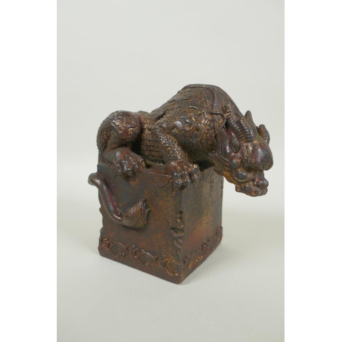 259 - A Chinese filled bronze figure of a kylin, with remnants of gilt and red lacquer patina, impressed Q... 