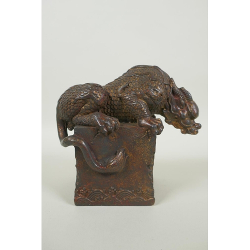 259 - A Chinese filled bronze figure of a kylin, with remnants of gilt and red lacquer patina, impressed Q... 