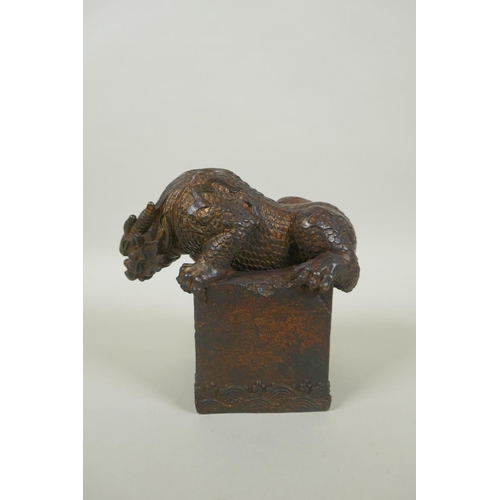 259 - A Chinese filled bronze figure of a kylin, with remnants of gilt and red lacquer patina, impressed Q... 