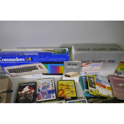 26 - Two Commodore 64, accessories, floppy disk readers, programs and games to include Ghostbusters, Supe... 