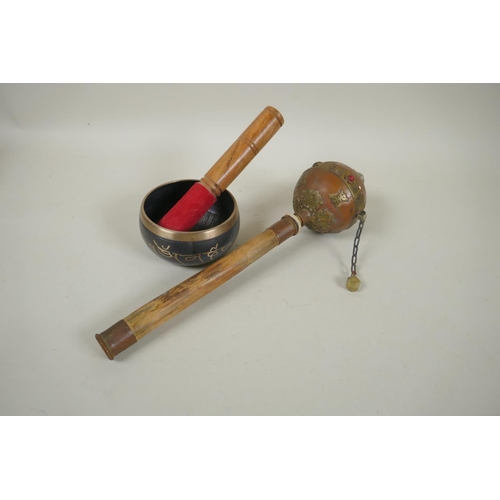 275 - A Tibetan bamboo and copper prayer wheel with brass mounts, and a bronze singing bowl with script de... 