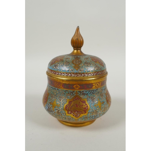 31 - An Islamic gilt brass and enamel sweet meat jar and cover, decorated with animals, figures and flowe... 