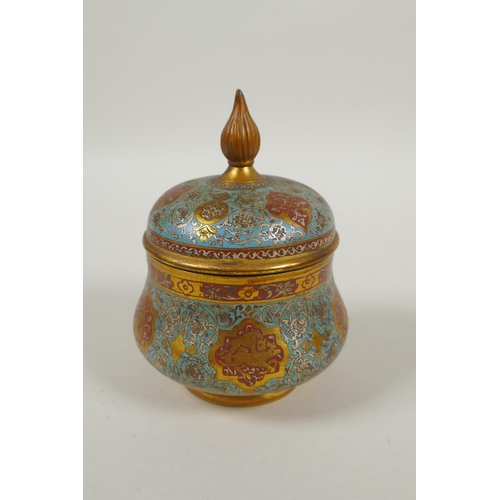 31 - An Islamic gilt brass and enamel sweet meat jar and cover, decorated with animals, figures and flowe... 