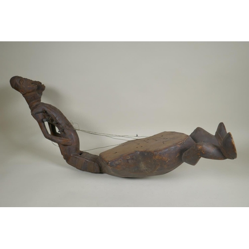 45 - An African early C20th Congolese carved wood Kundi harp with figural decoration, 68cm long