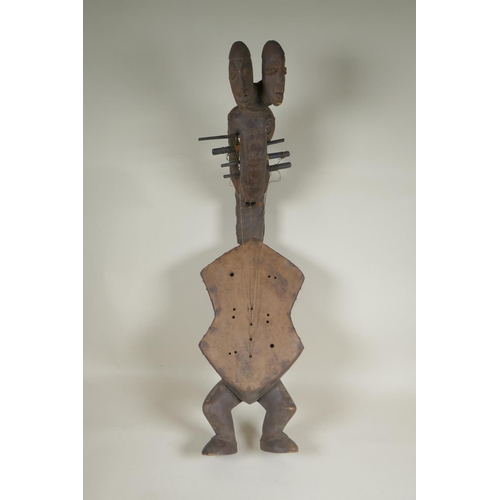 45 - An African early C20th Congolese carved wood Kundi harp with figural decoration, 68cm long