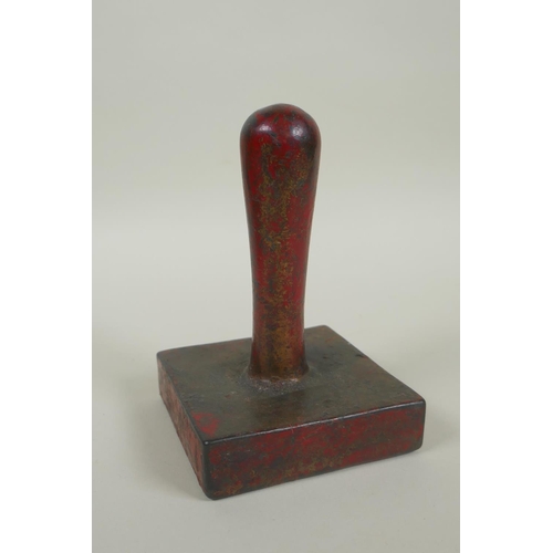 55 - A Chinese red lacquer and gilt bronze hand seal, 13cm high