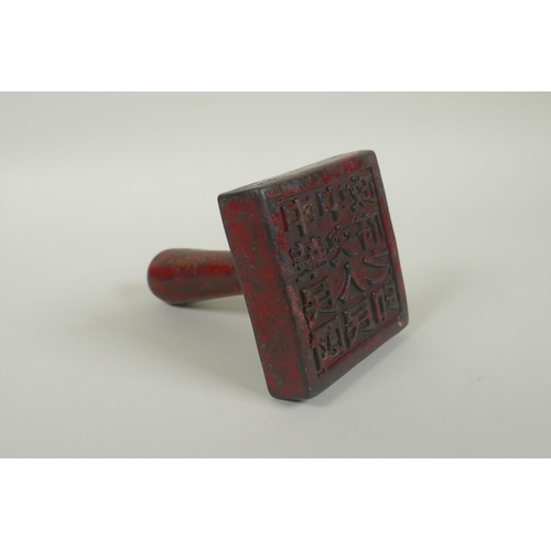 55 - A Chinese red lacquer and gilt bronze hand seal, 13cm high