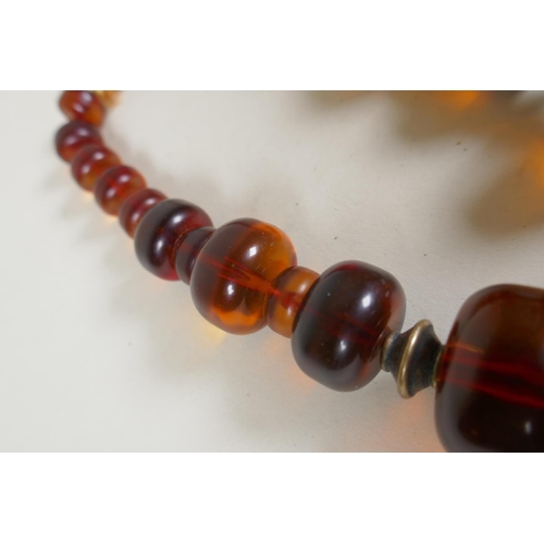 604 - A graduated honey amber bead necklace, 136g gross