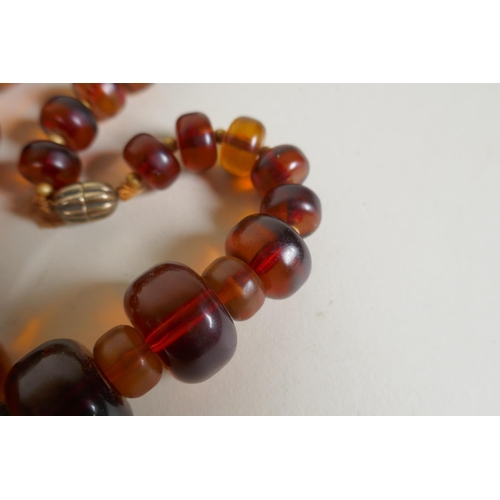 604 - A graduated honey amber bead necklace, 136g gross