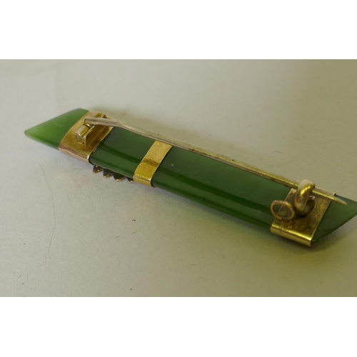 653 - A vintage jade bar brooch set with yellow metal mounts