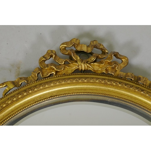 73 - An antique Empire style ormolu hanging wall mirror with bevelled glass, 28cm high