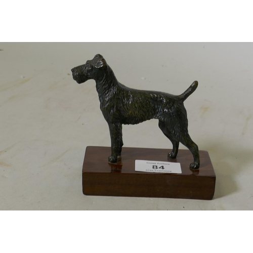 84 - An antique bronzed metal figure of an Airedale terrier, mounted on a wood base, 11.5cm high