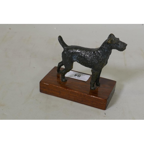 84 - An antique bronzed metal figure of an Airedale terrier, mounted on a wood base, 11.5cm high