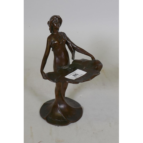 86 - An Art Nouveau style bronzed white metal card tray in the form of a woman holding lily pads, 21cm hi... 