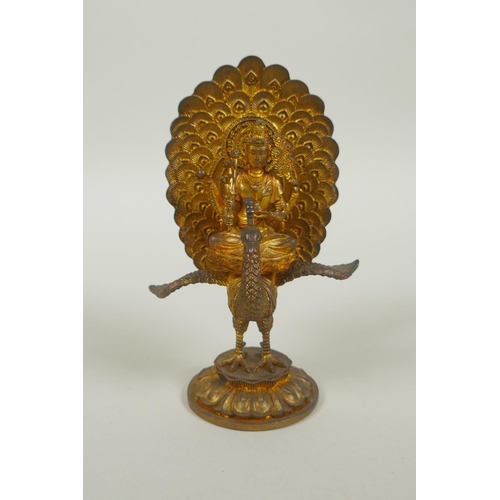 91 - A Sino Tibetan gilt bronze figure of Buddha seated on the back of a phoenix, 12cm high