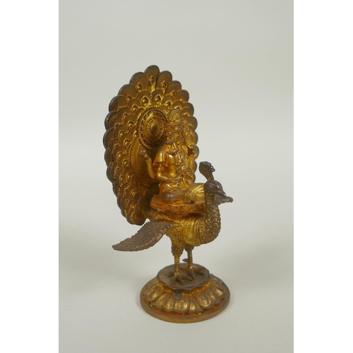 91 - A Sino Tibetan gilt bronze figure of Buddha seated on the back of a phoenix, 12cm high