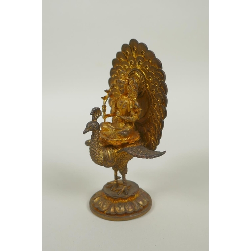 91 - A Sino Tibetan gilt bronze figure of Buddha seated on the back of a phoenix, 12cm high