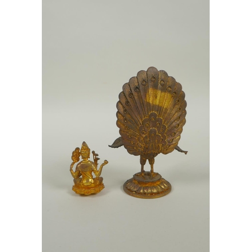 91 - A Sino Tibetan gilt bronze figure of Buddha seated on the back of a phoenix, 12cm high