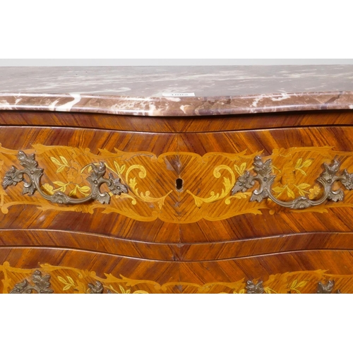 1002 - A Louis XV style marquetry inlaid serpentine front tulipwood commode with three drawers, rouge marbl... 