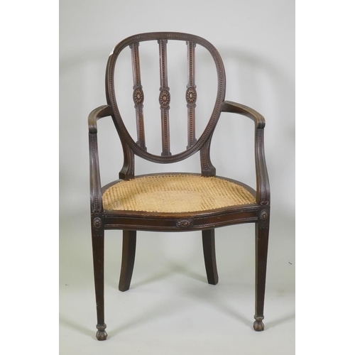 1013 - A walnut Adam style elbow chair, with carved paterae and bead decoration, and serpentine front, rais... 