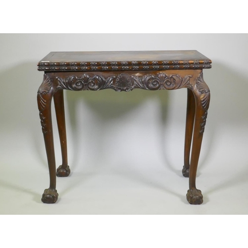 1018 - Chippendale style card table with fold over top and carved decoration, raised on cabriole supports w... 