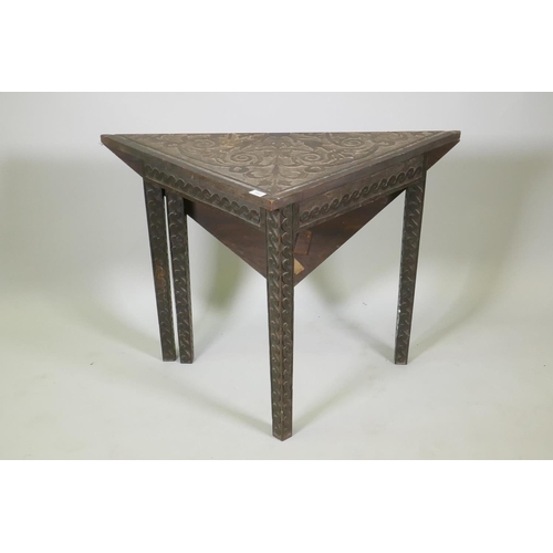 1023 - C19th Flemish oak drop leaf corner table, the frieze and legs carved with a Vitruvian scroll, the to... 