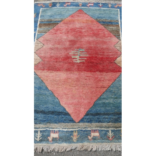 1026 - An oriental deep pile woven wool carpet with geometric design and blue border, 200 x 150cm